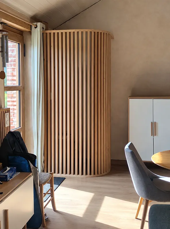 Claustra arrondi en tasseaux de bois, posé en intérieur par Antho Rénova